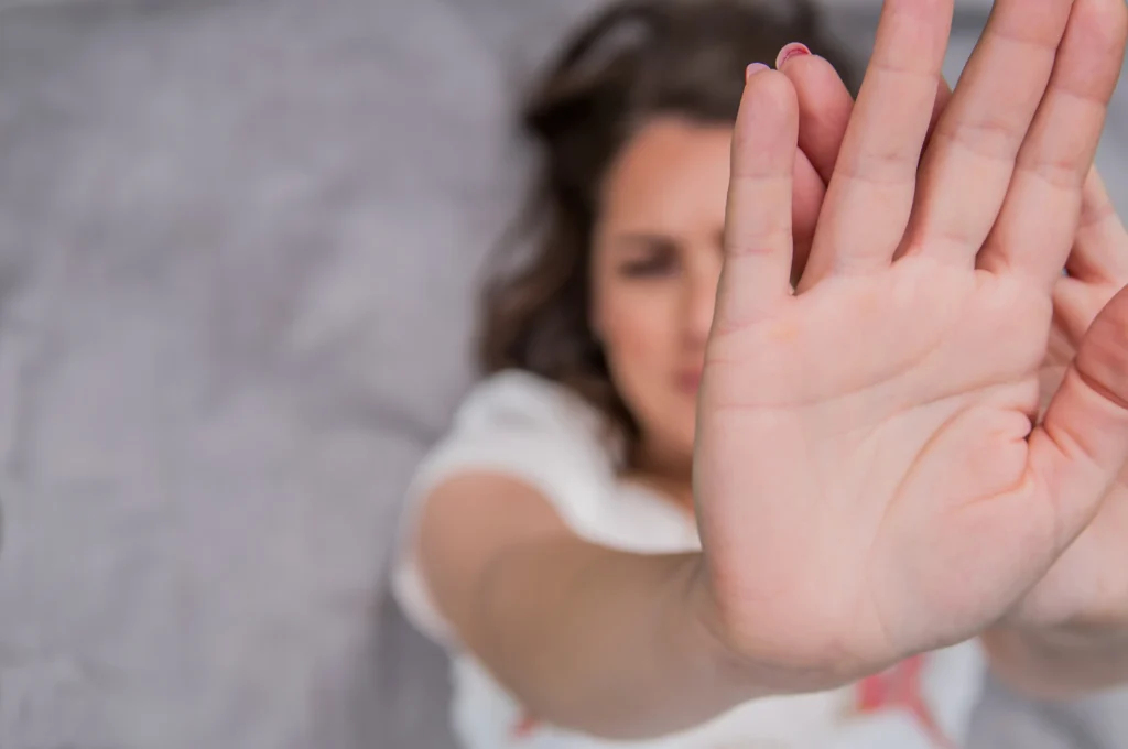 Mujer con mano levantado a modo de stop