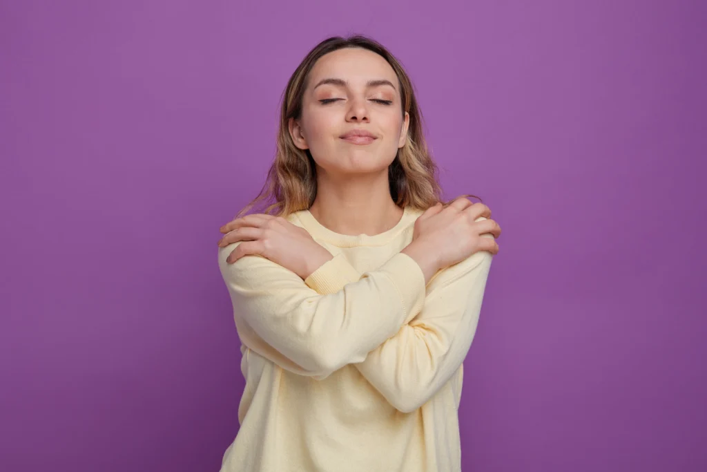 mujer abrazándose sobre fondo violeta